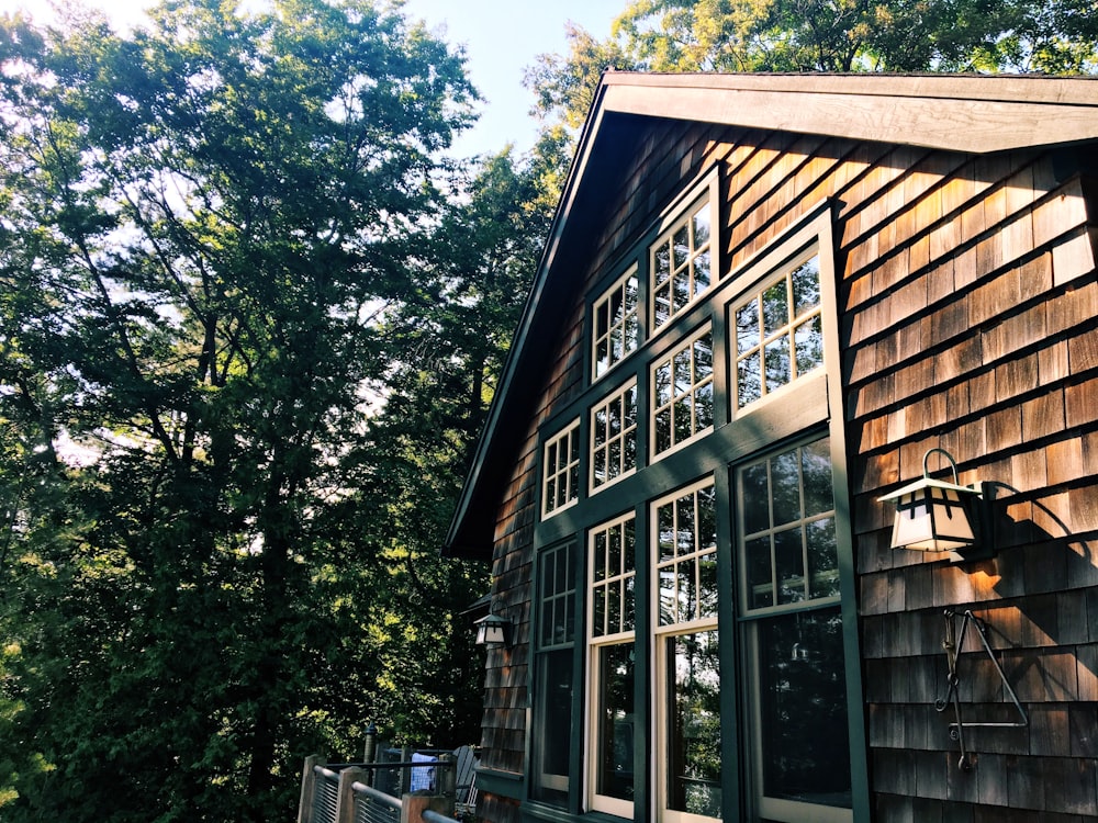 brown and white wooden house near green trees during daytime