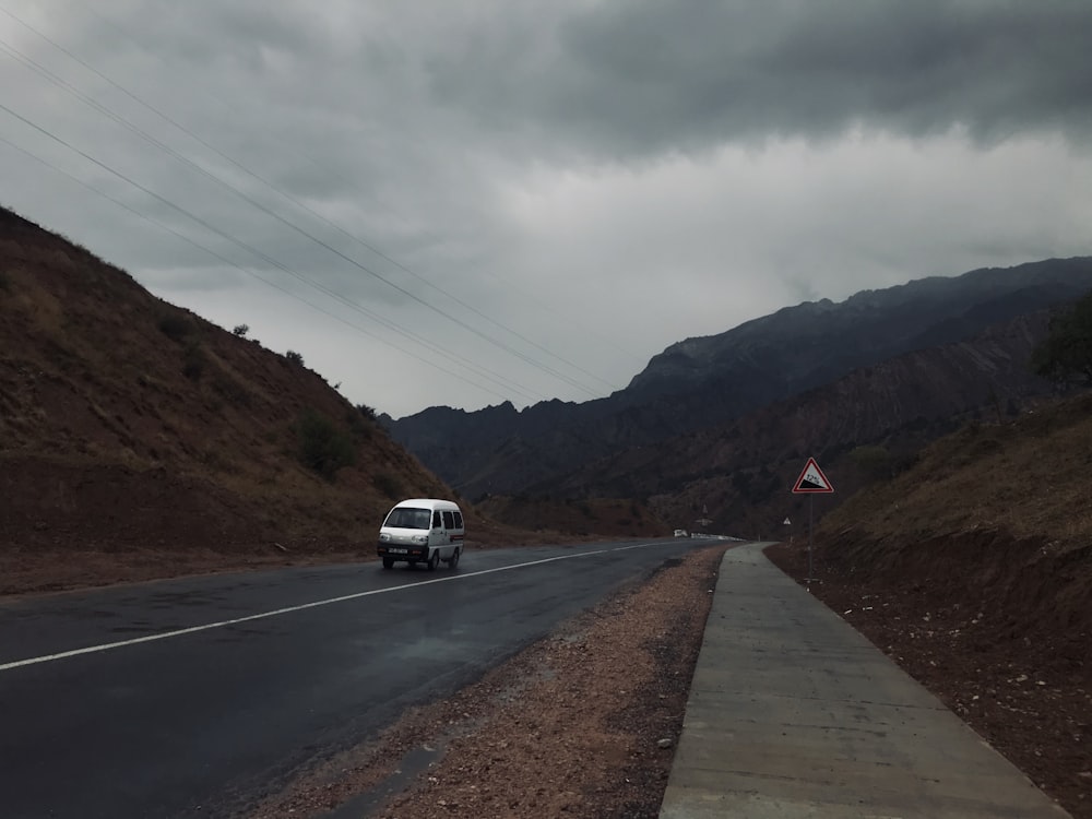 white car on road near mountain during daytime