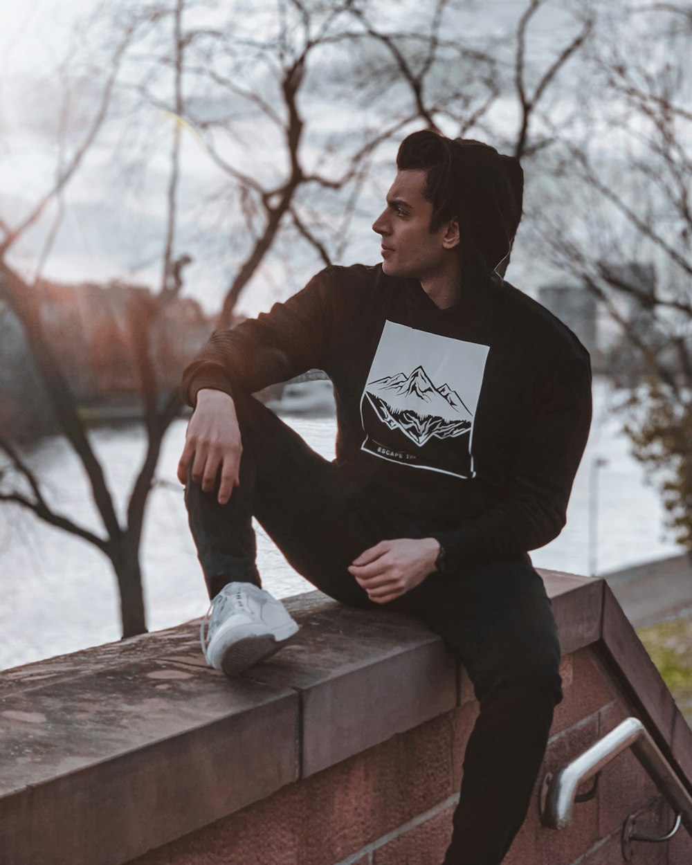 man in black long sleeve shirt sitting on brown wooden bench during daytime