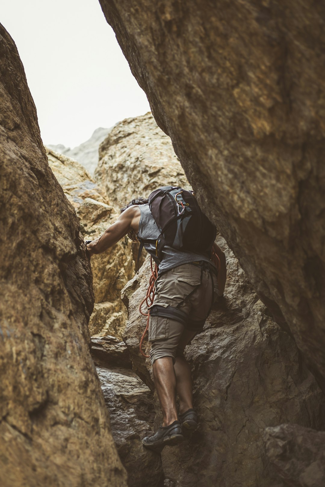 man in black jacket climbing on brown rock mountain during daytime