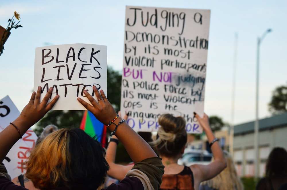 woman holding white and black quote board during daytime