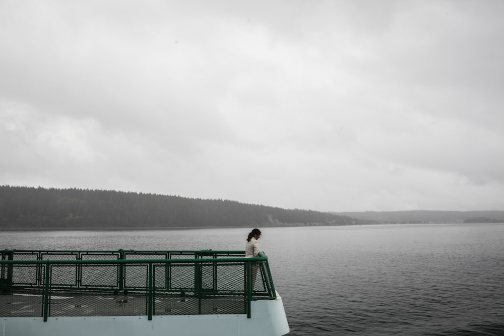 woman in green dress sitting on green wooden bench