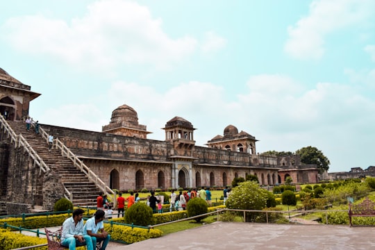 people walking on park near brown concrete building during daytime in Jahaz Mahal India