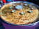 A close-up of a steaming hot, golden-brown paratha served with vibrant chutneys and a side of fresh salad.