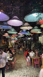 Lively restaurant terrace with guests enjoying coastal Goan dishes under string lights.