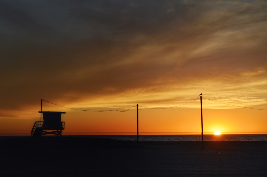 silhouette of a boat on sea during sunset