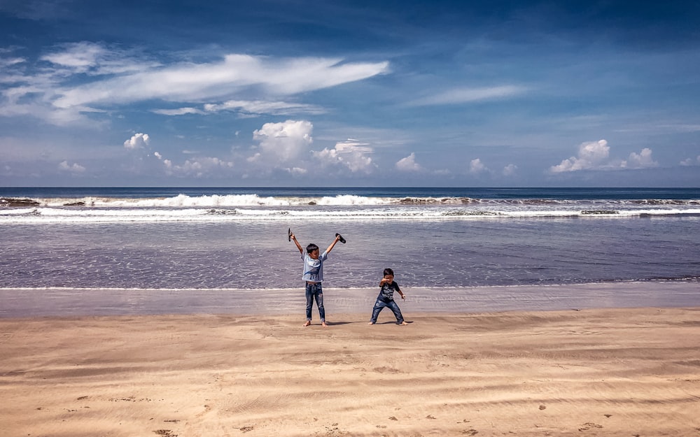 2 women standing on beach during daytime