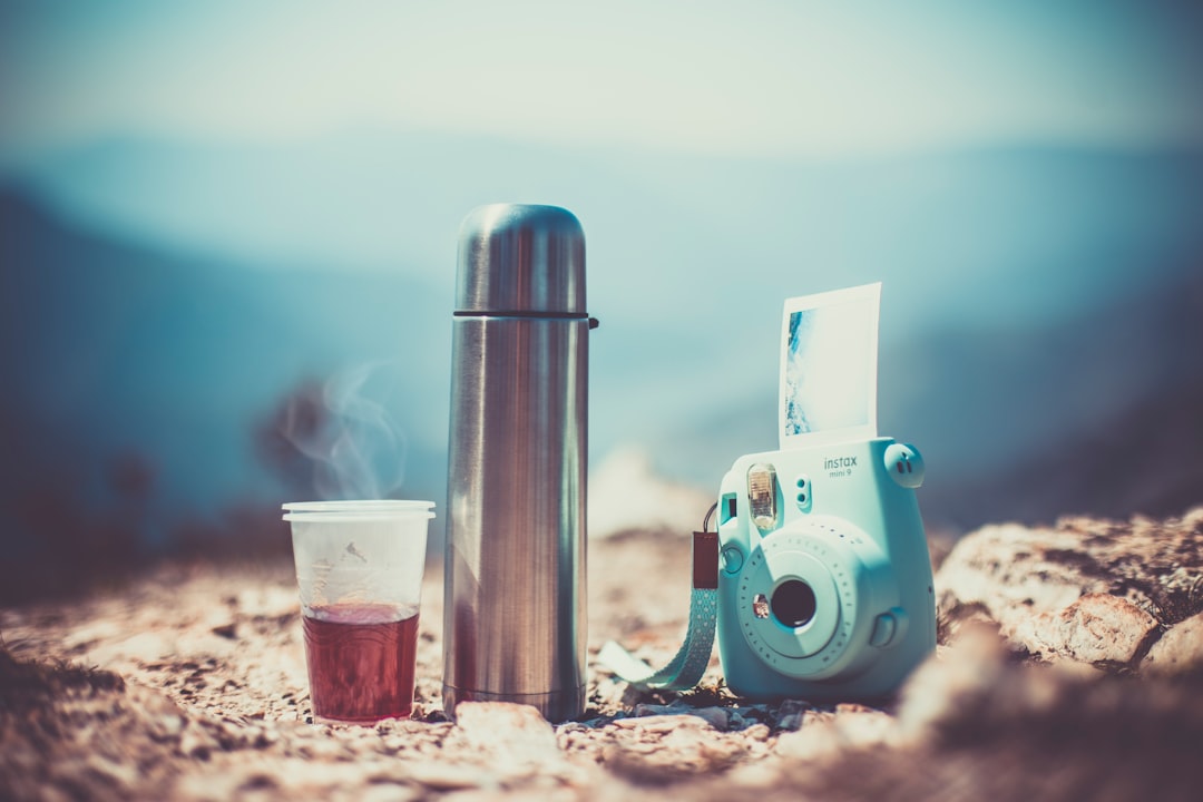 white and blue robot toy beside clear drinking glass