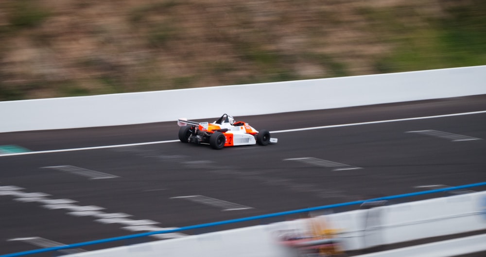 black and orange f 1 car on track