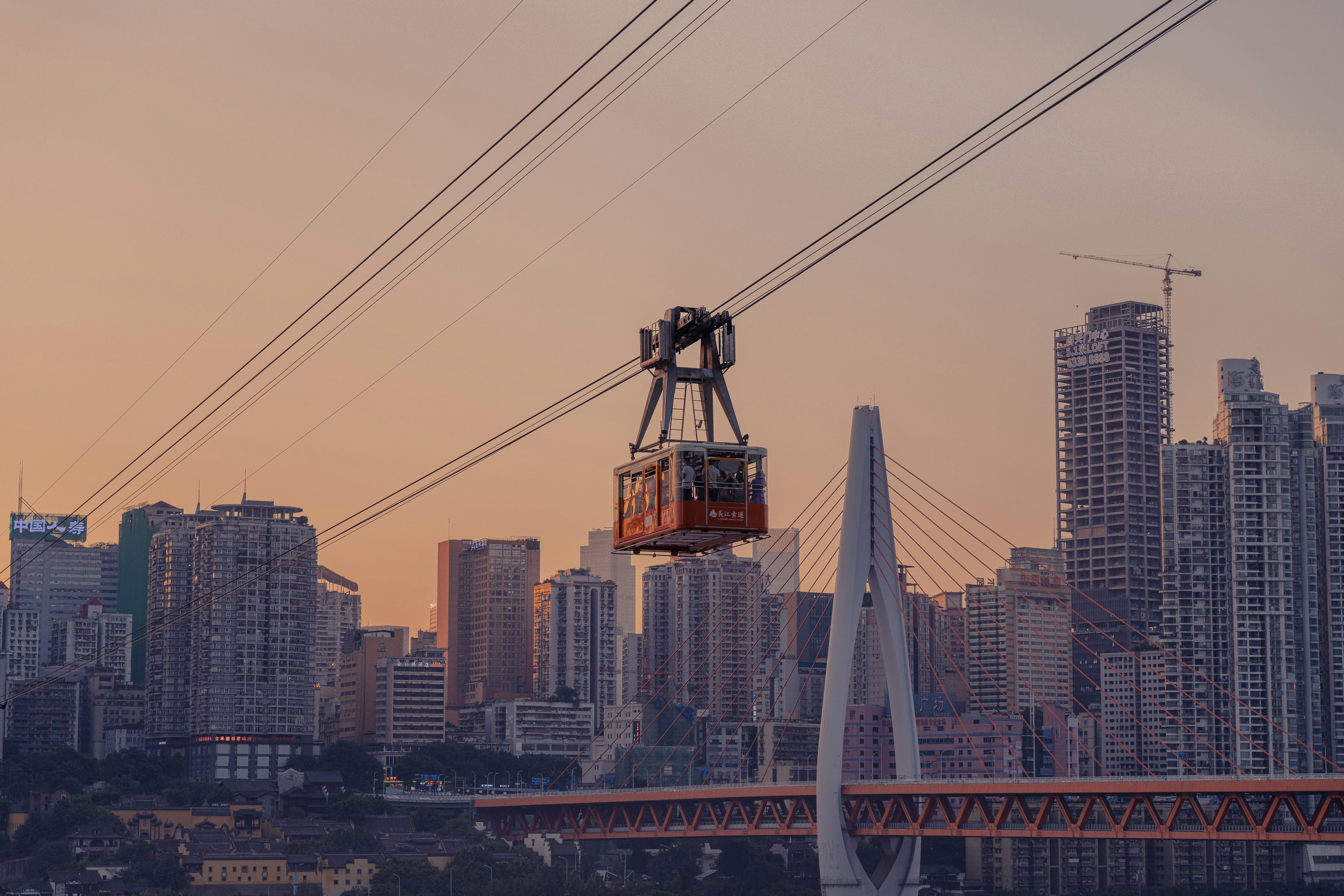 orange and black crane near city buildings during daytime