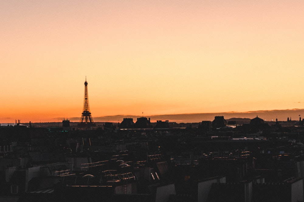 city buildings under orange sky during sunset