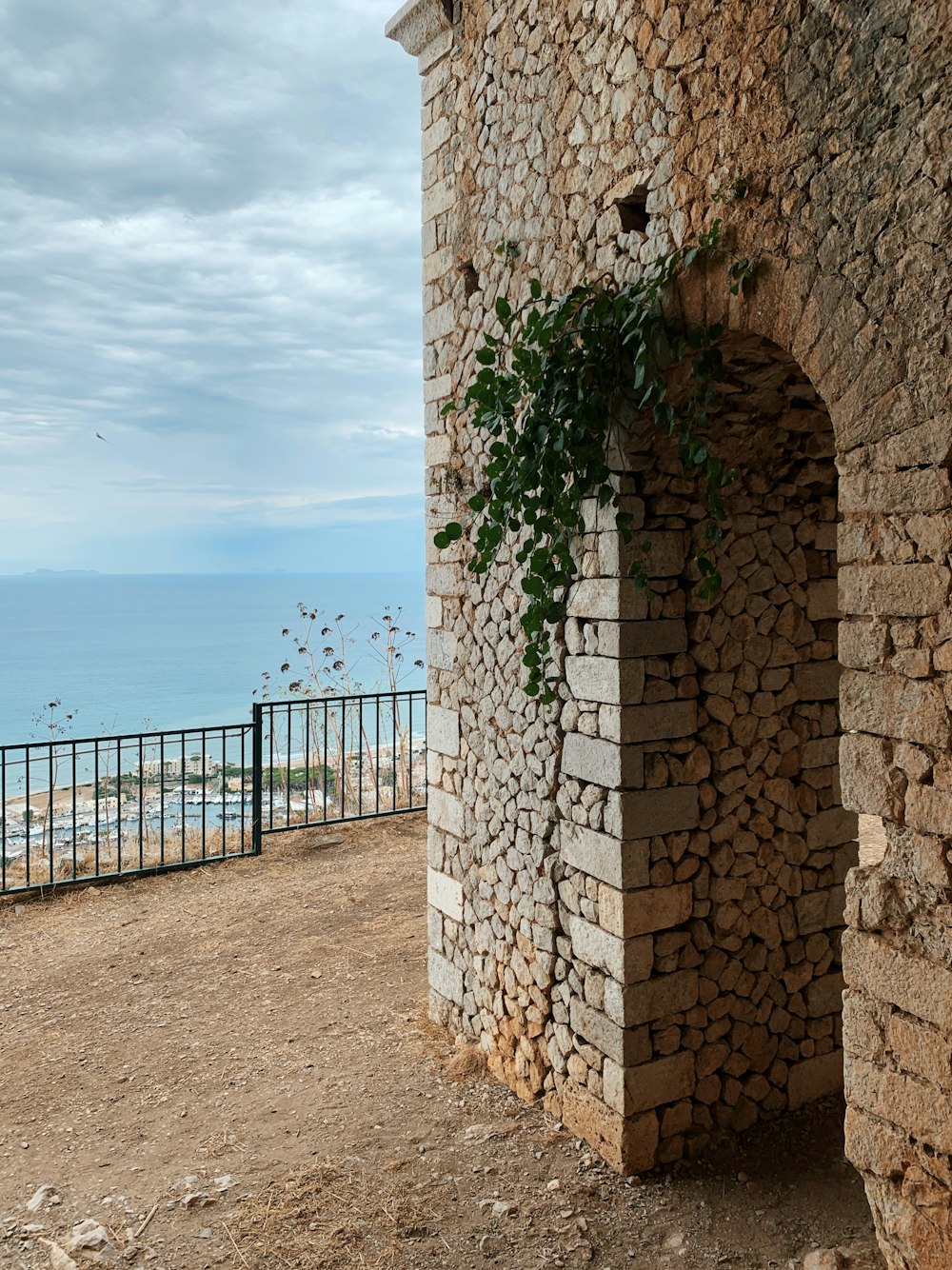 brown concrete building near sea under white clouds and blue sky during daytime