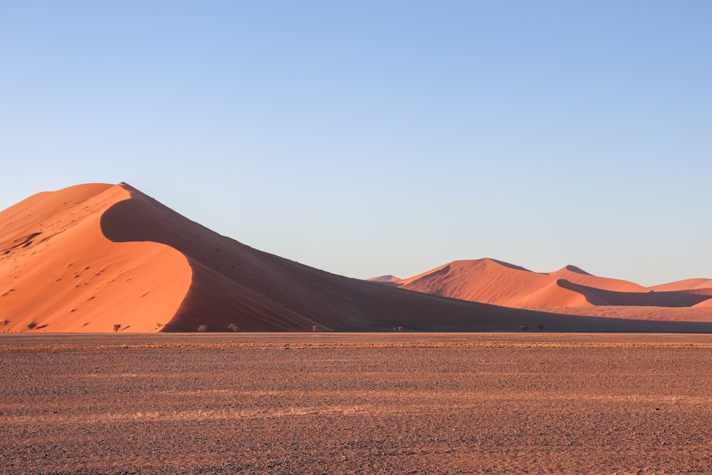 campo de areia marrom perto da montanha marrom durante o dia