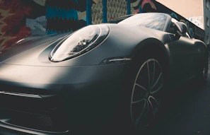 A shiny sports car parked outdoors showcasing a full-body wrap with a matte finish.