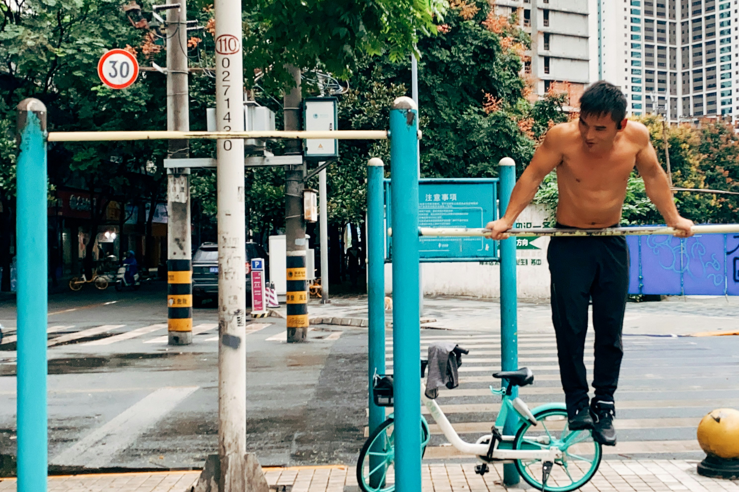 boy in black tank top and black shorts riding green bicycle during daytime