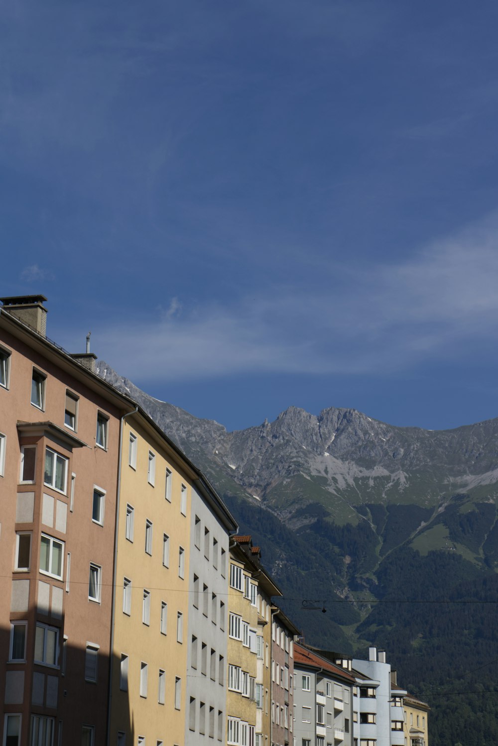 brown concrete building near mountain under blue sky during daytime