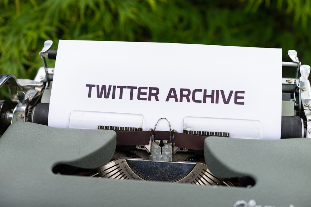 a close up of a typewriter with a paper that reads twitterr archive