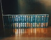 Elegant hardcover academic books stacked with a blue and gold color scheme.