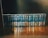 A neatly arranged collection of books with identical dark blue covers and gold lettering sits on a wooden shelf. Each book is uniformly positioned, creating a visually appealing display.