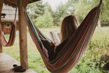 woman reading book on hammock