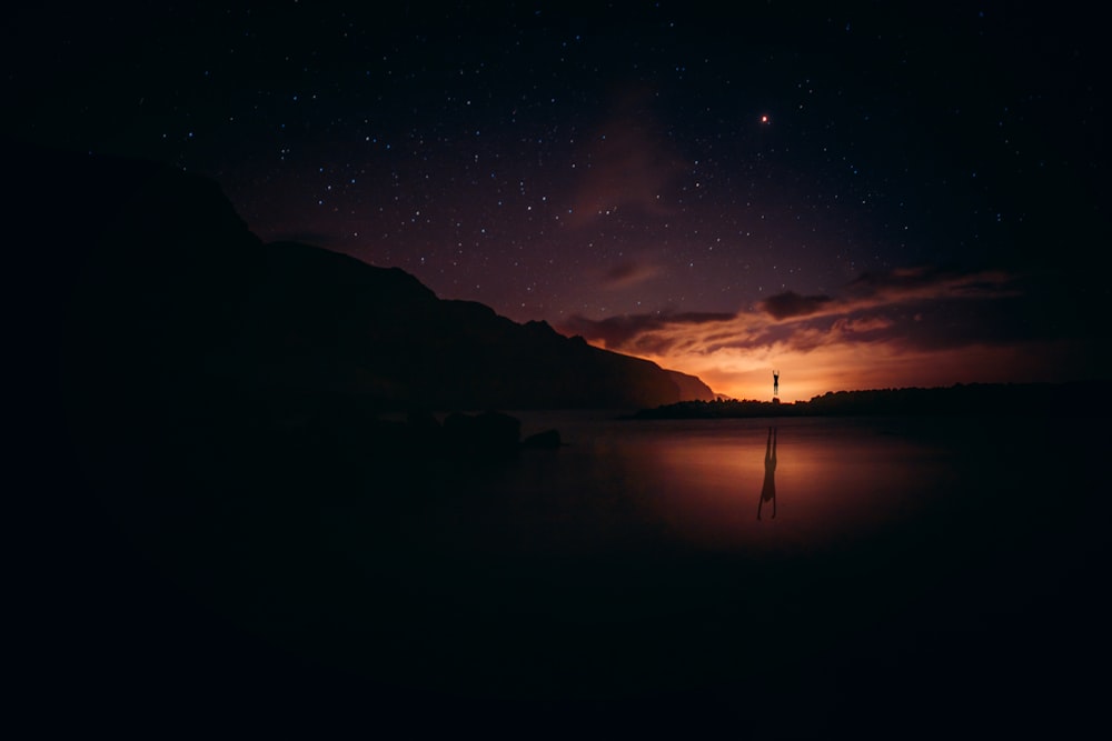 silhouette of mountain during night time