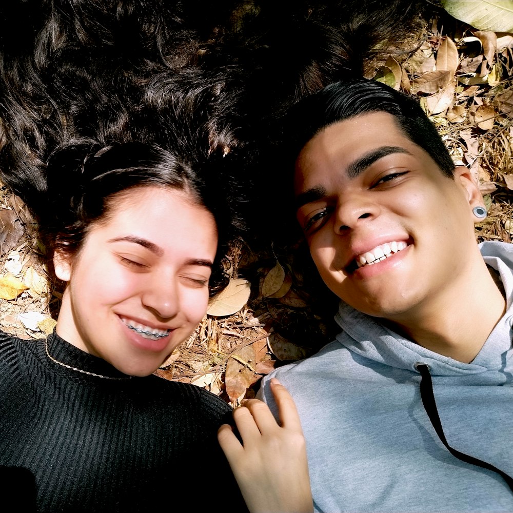 woman in black sweater lying on brown leaves