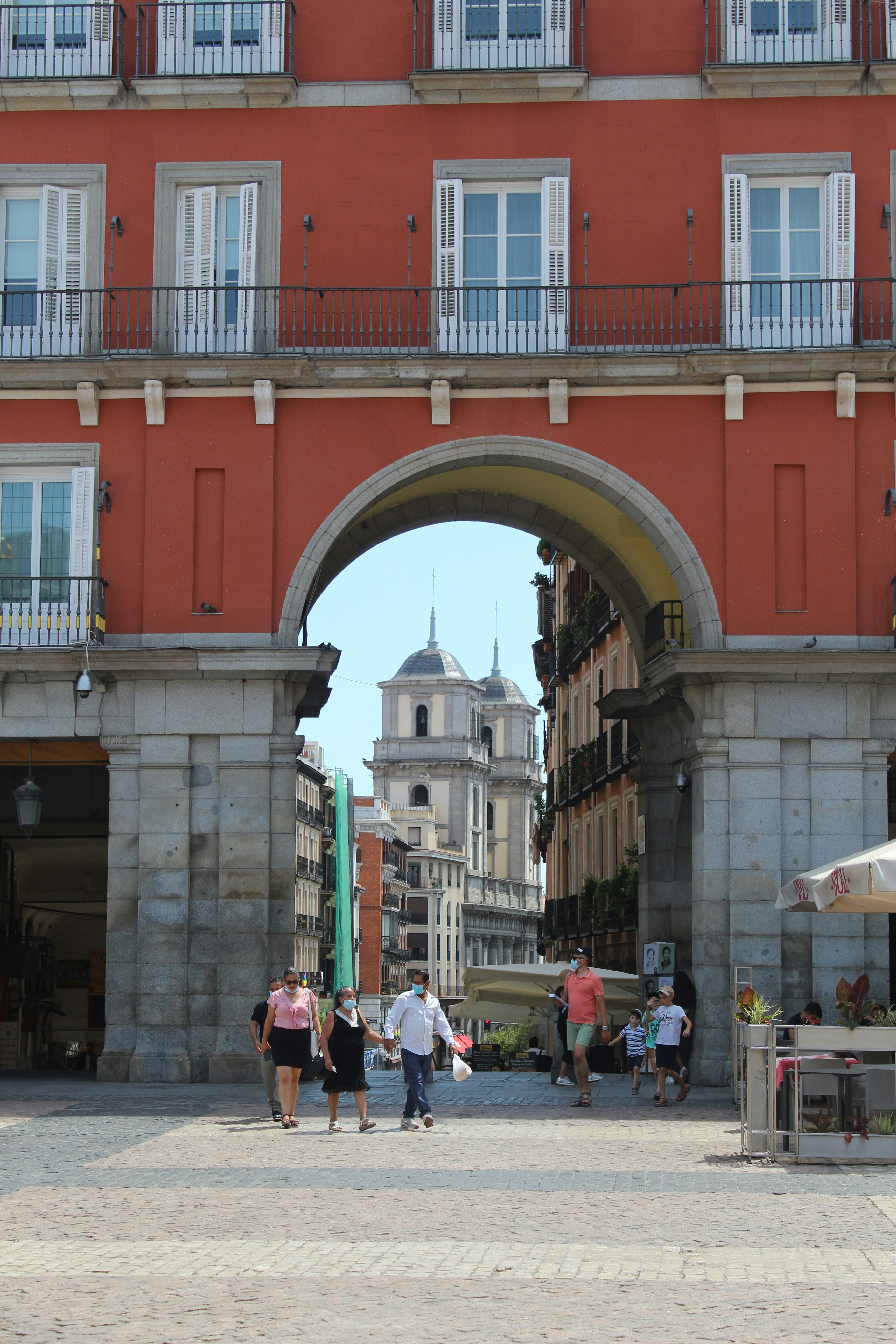 Personas caminando por la calle cerca de un edificio de hormigón marrón durante el día