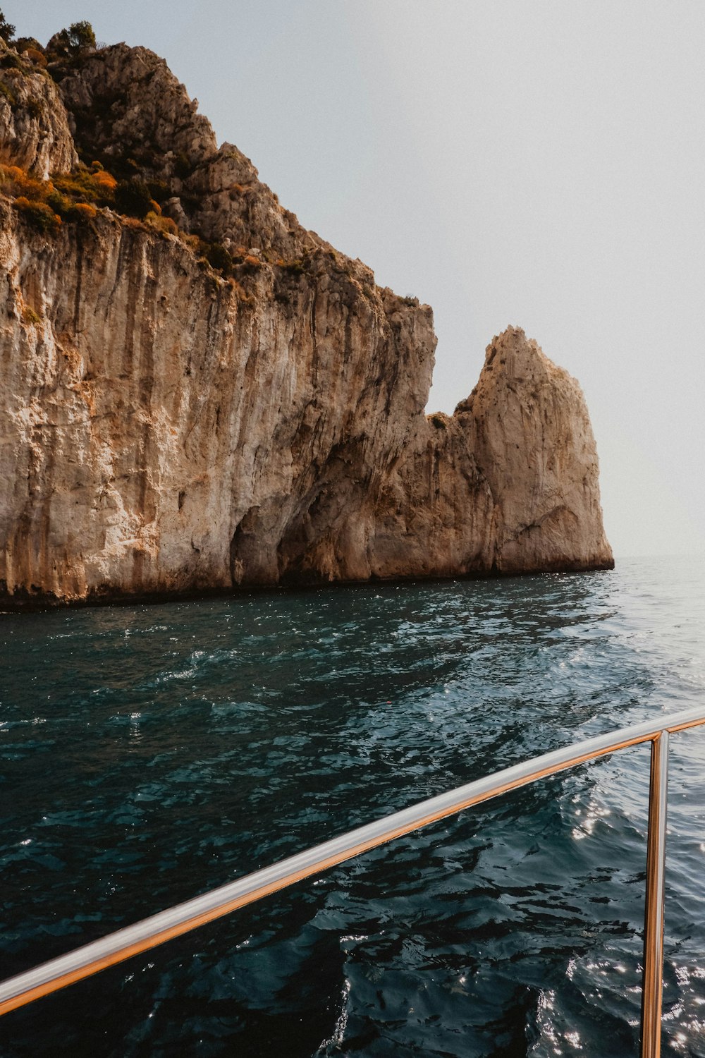 brown rock formation beside body of water during daytime