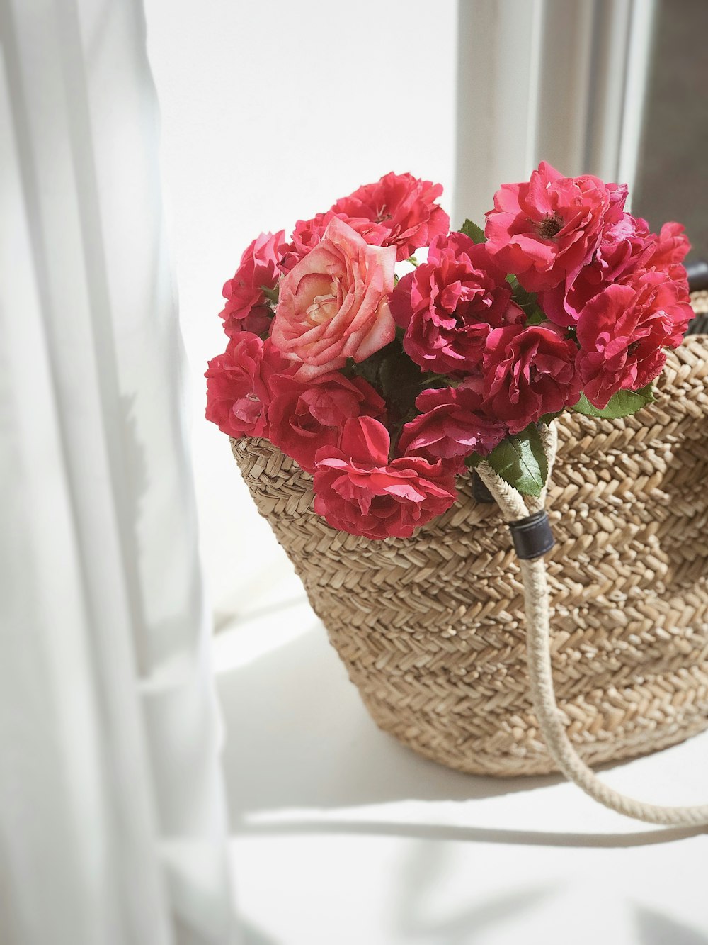 pink roses in brown wicker basket