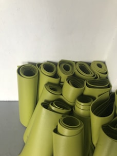 A close-up of colorful yoga mats rolled out on a sunlit studio floor.