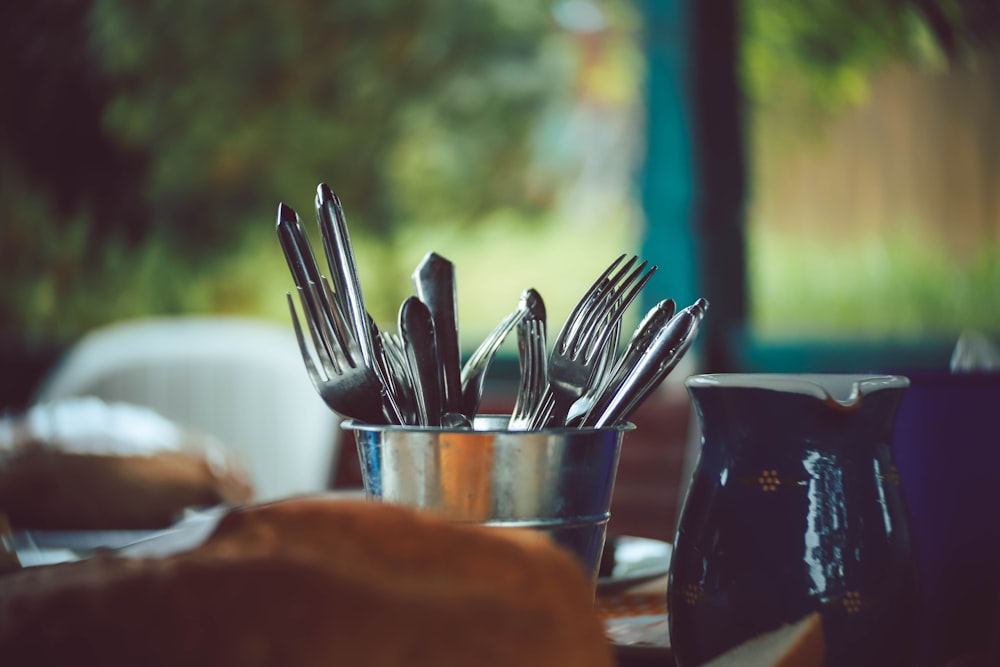 stainless steel spoons and forks on stainless steel round container