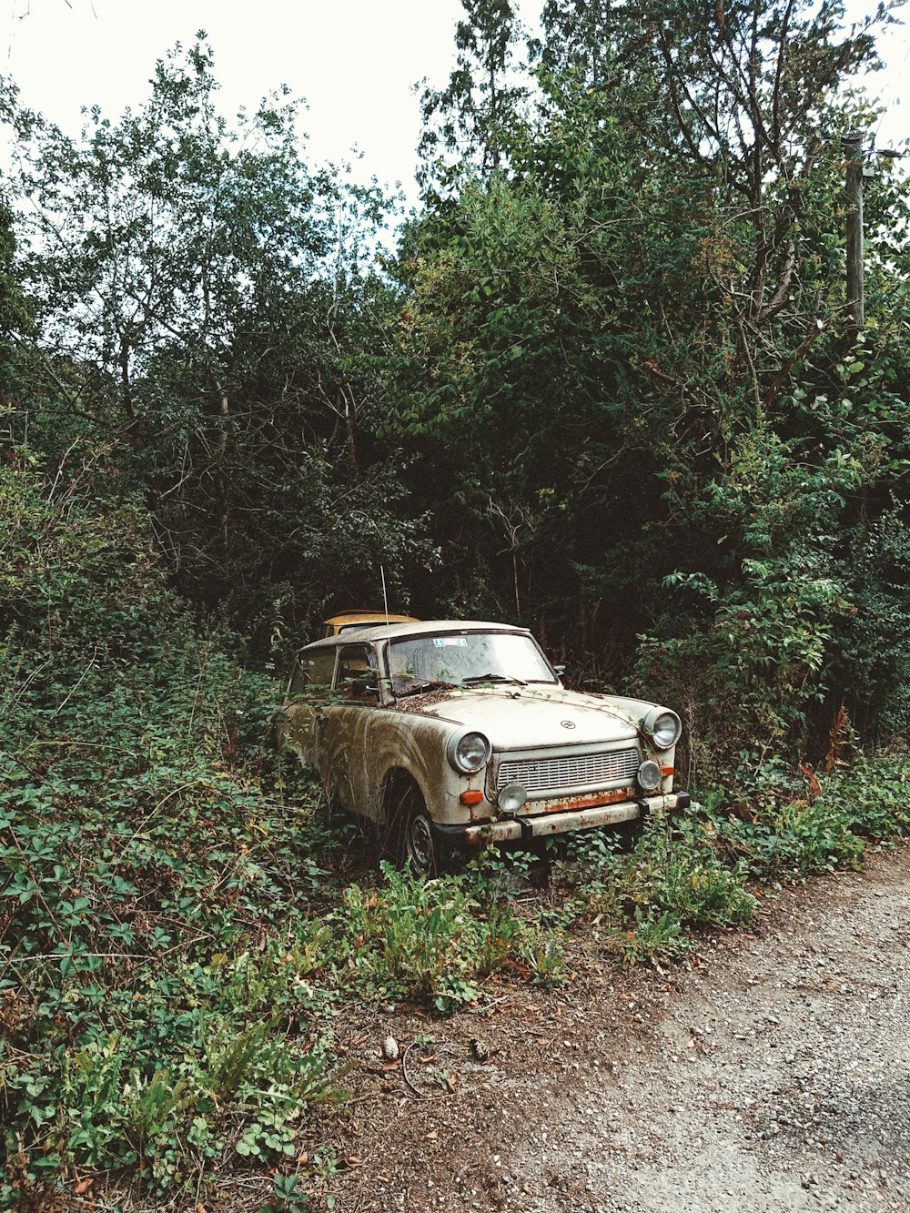 yellow and white vintage car on brown dirt road