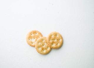 two brown cookies on white surface