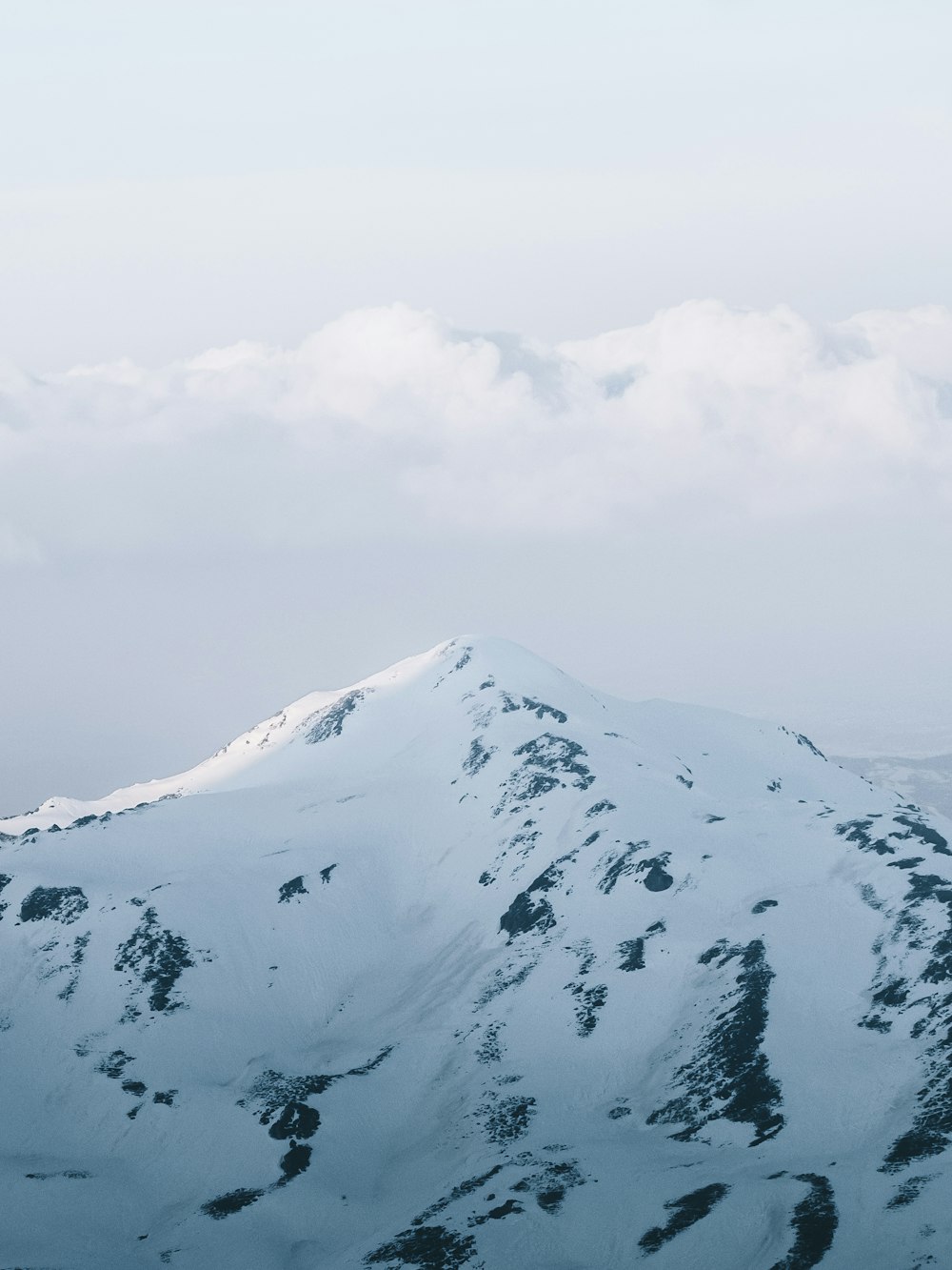 snow covered mountain under cloudy sky during daytime