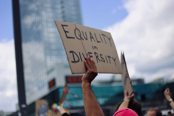 a sign reading "equality in diversity" being held up at a protest rally