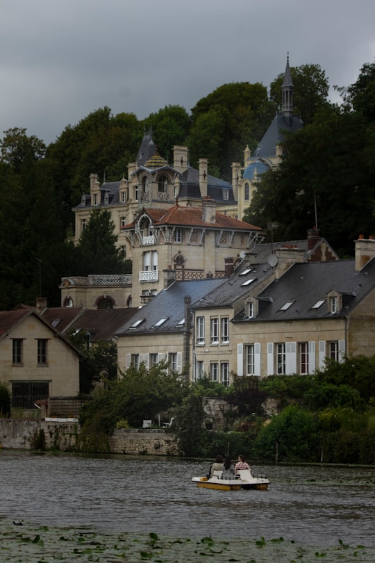 white and brown concrete building near green trees during daytime in Pierrefonds France