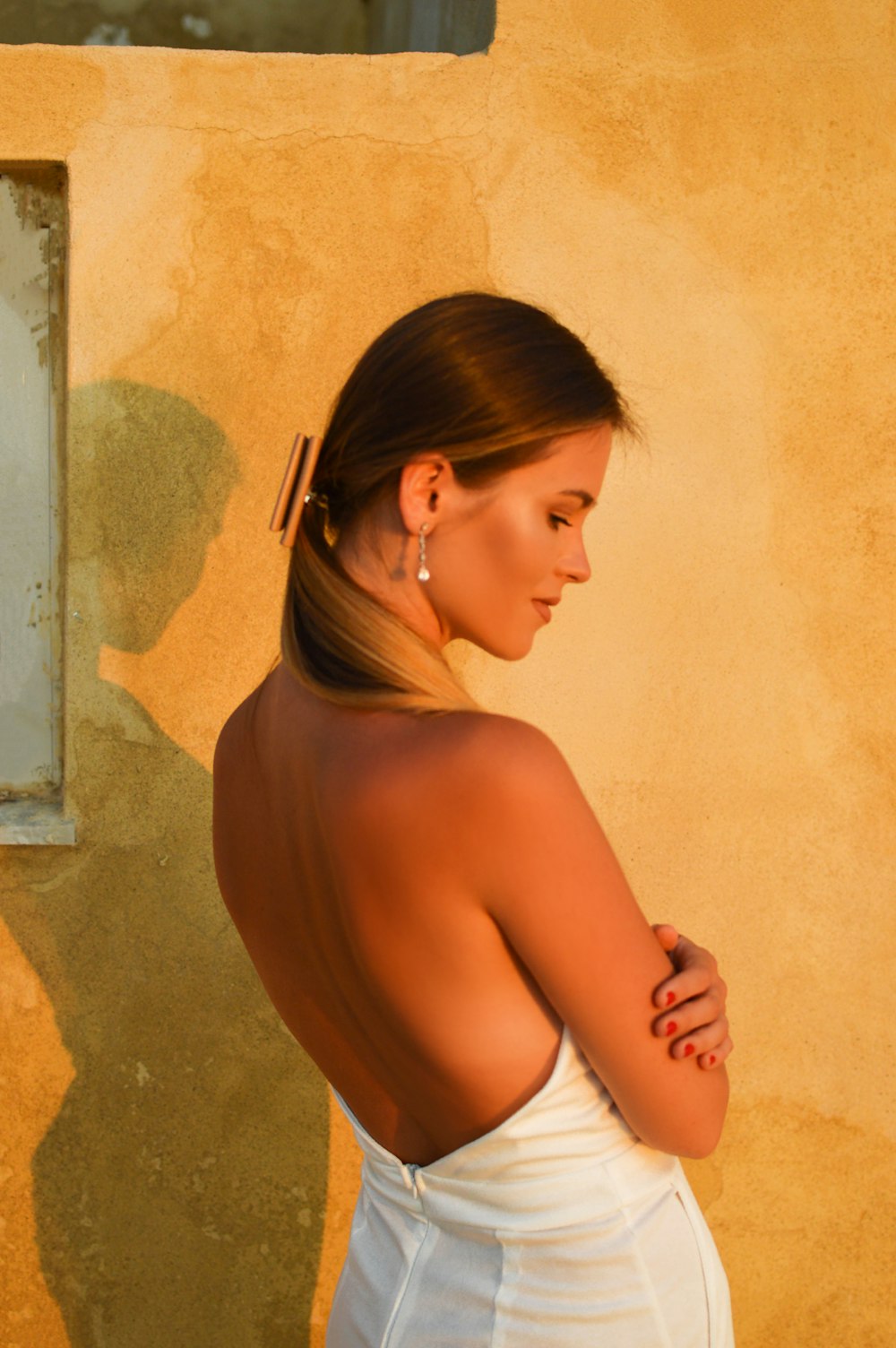 woman in white panty leaning on wall