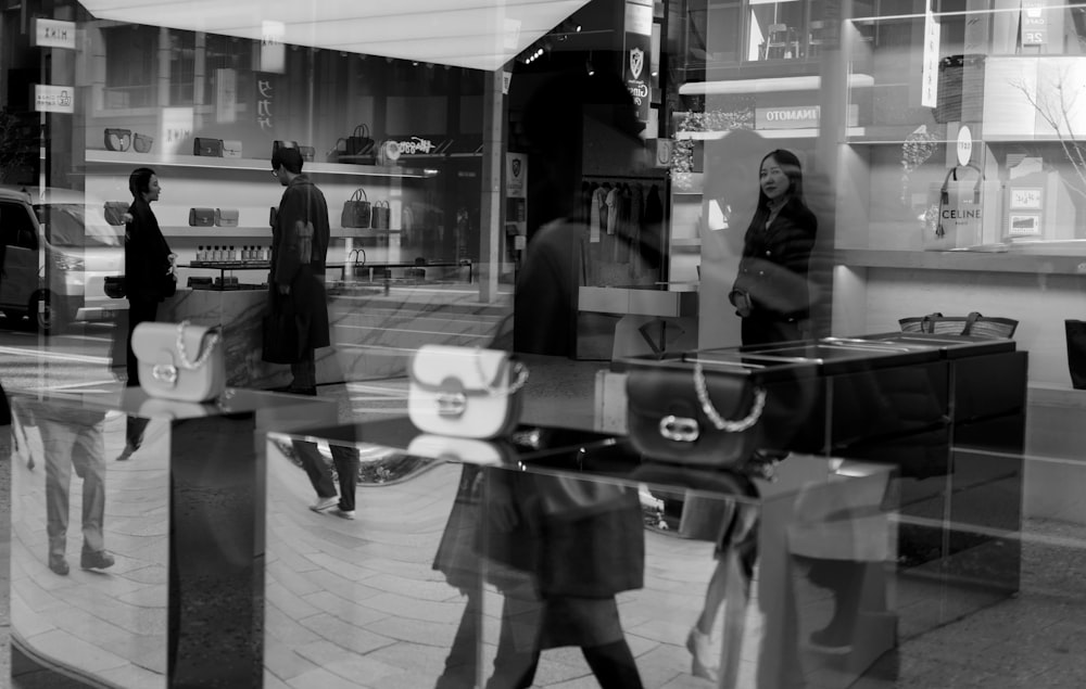 donna in cappotto nero in piedi vicino alla parete di vetro