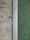 A close-up view of a surface transition featuring a concrete slab on the left and a textured green surface on the right. Separating the two areas is a metal strip with a series of evenly spaced circular holes, likely serving as drainage.