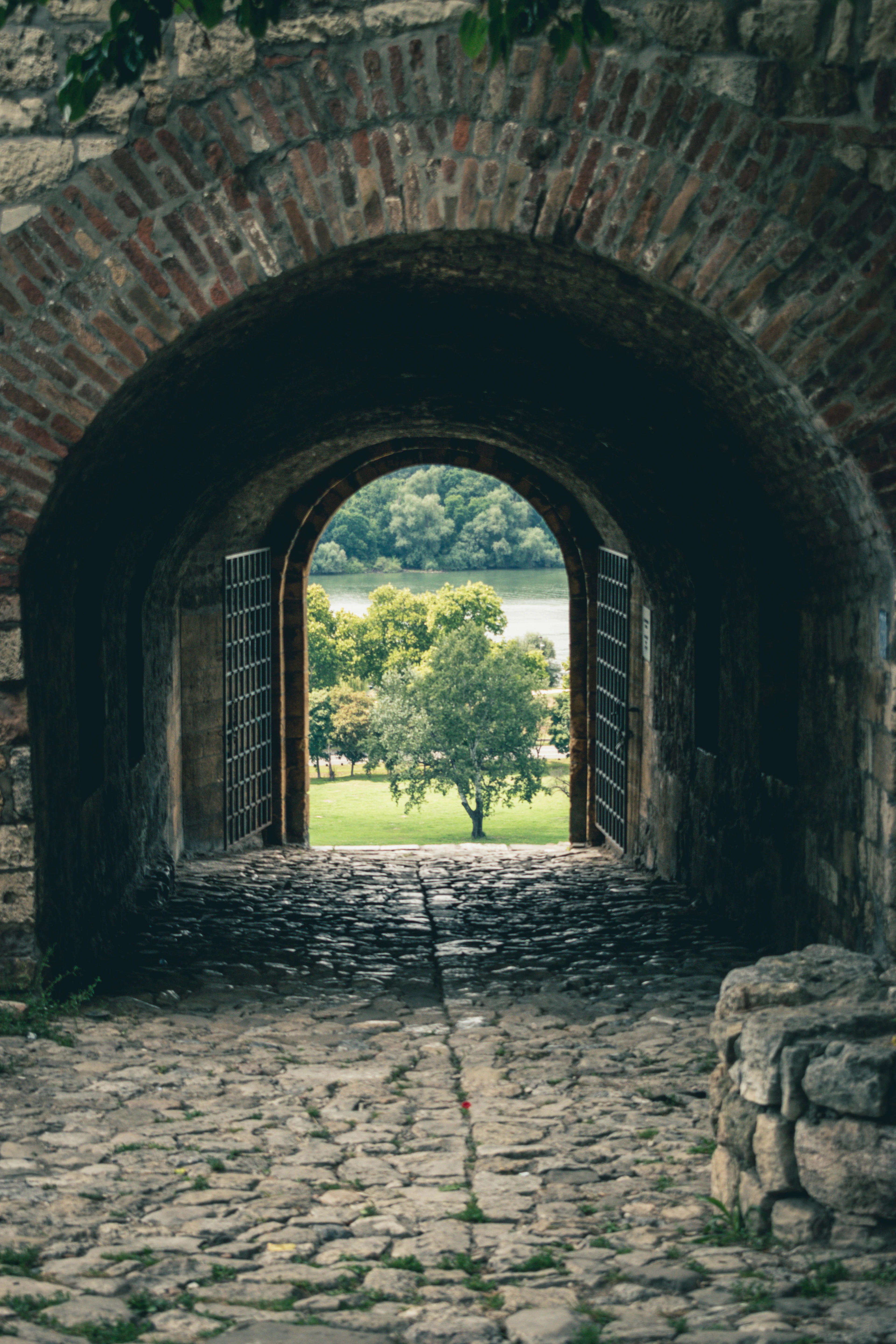 A brick archway of Kalemegdan Fortress framing a view of trees and the river beyond