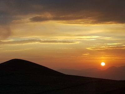 Sunset over a spacious lot with gentle hills.