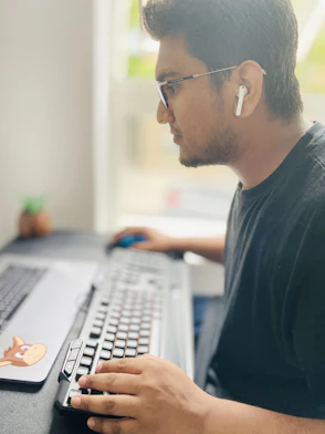 man in black crew neck shirt using computer