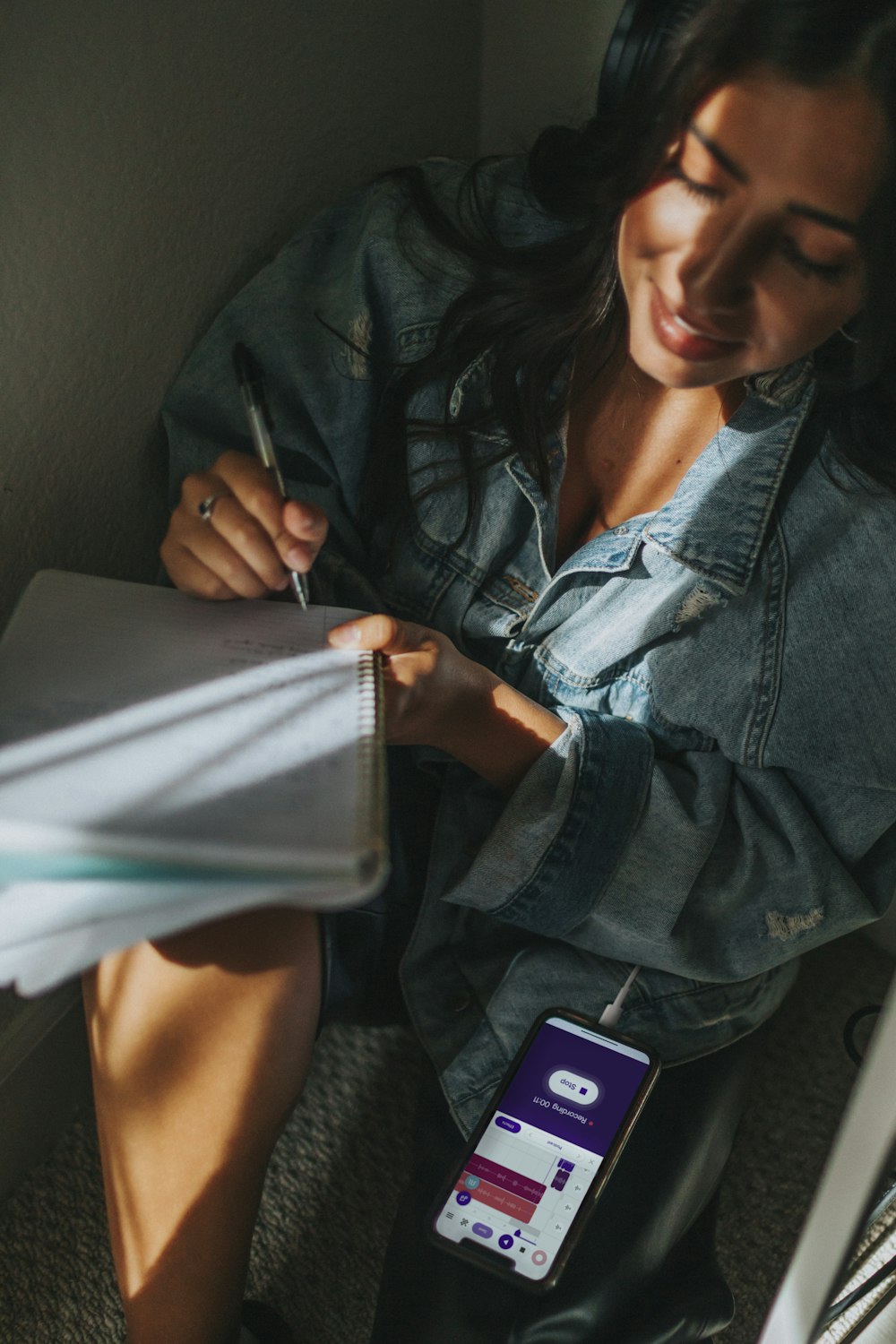 woman in blue denim jacket holding white paper