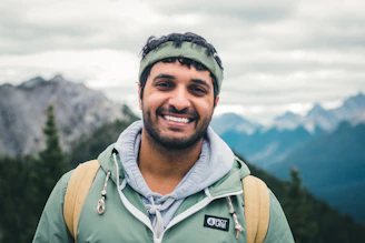 man in green zip up jacket smiling