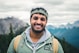 man in green zip up jacket smiling