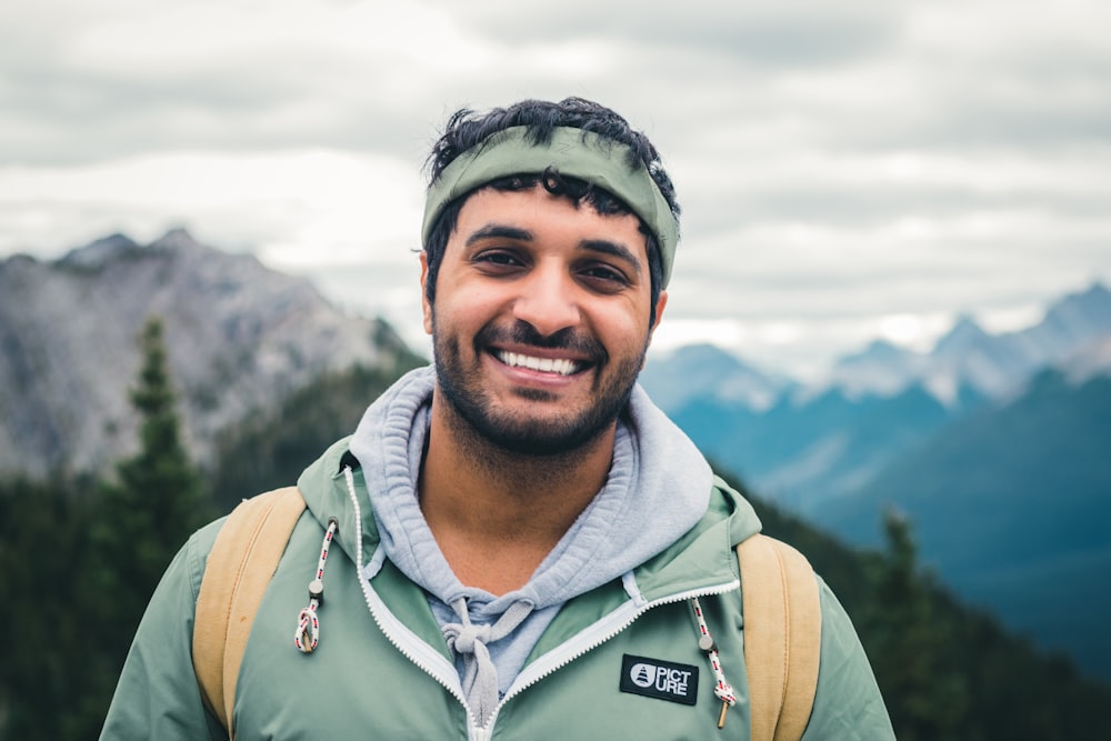 man in green zip up jacket smiling