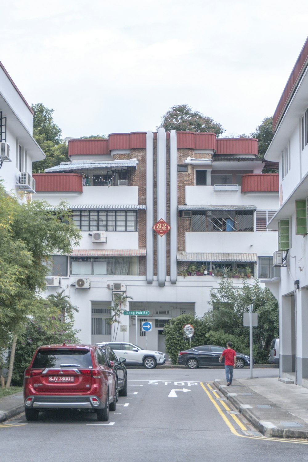 cars parked in front of white and red concrete building during daytime