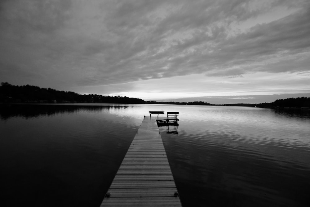 grayscale photo of dock on lake