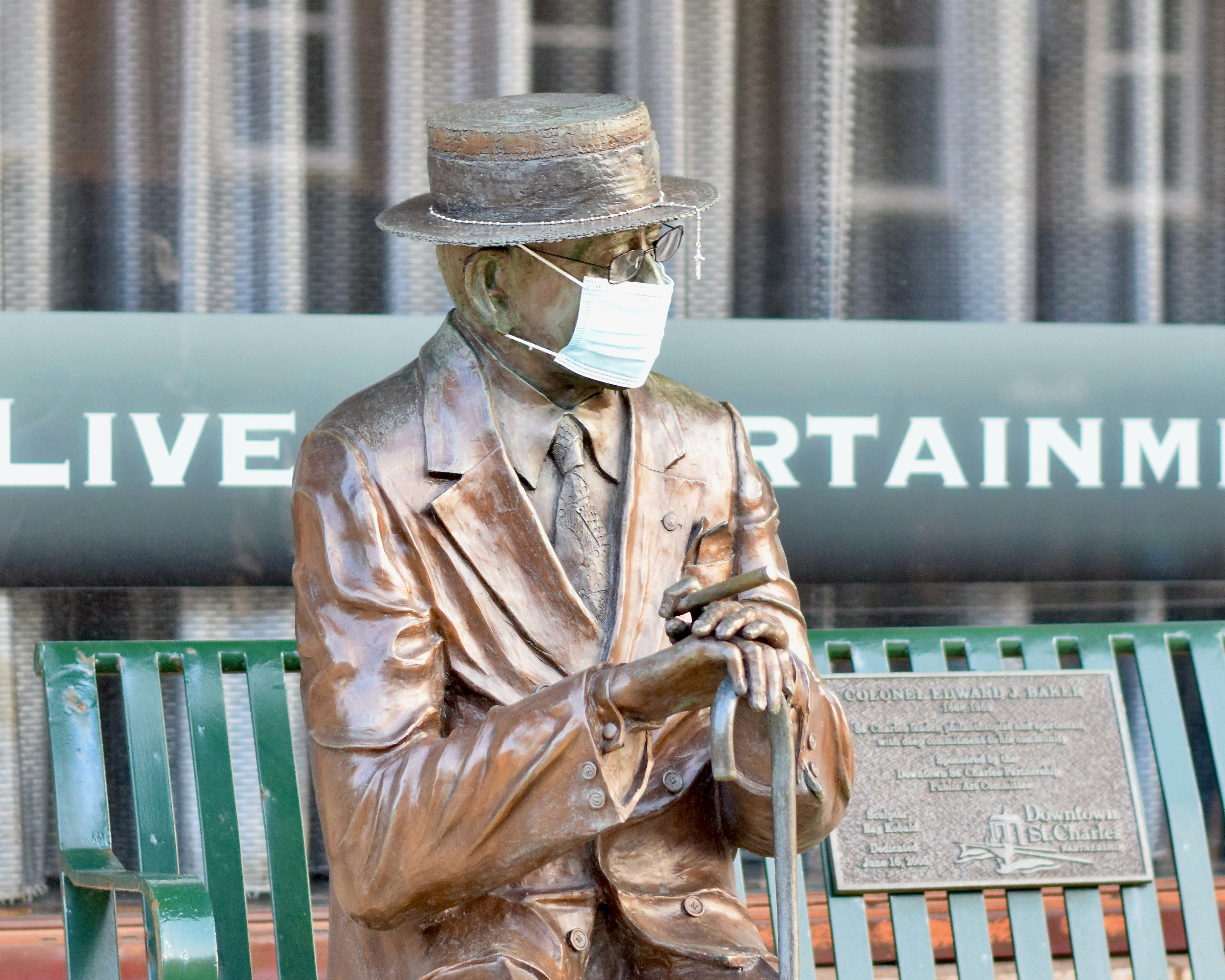 uomo in giacca di pelle marrone e cappello beige seduto sulla panchina