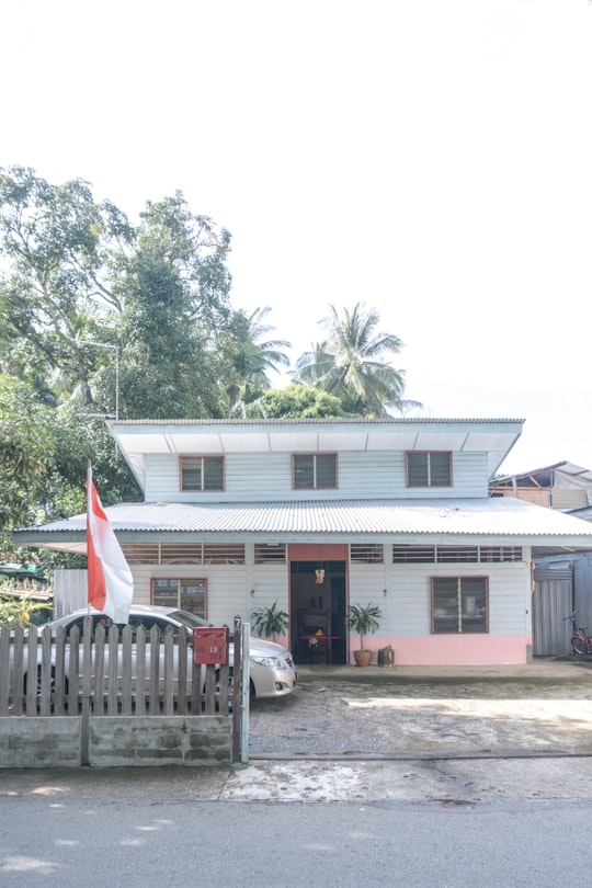 white and brown wooden house near green trees during daytime in Kampung Lorong Buangkok Singapore